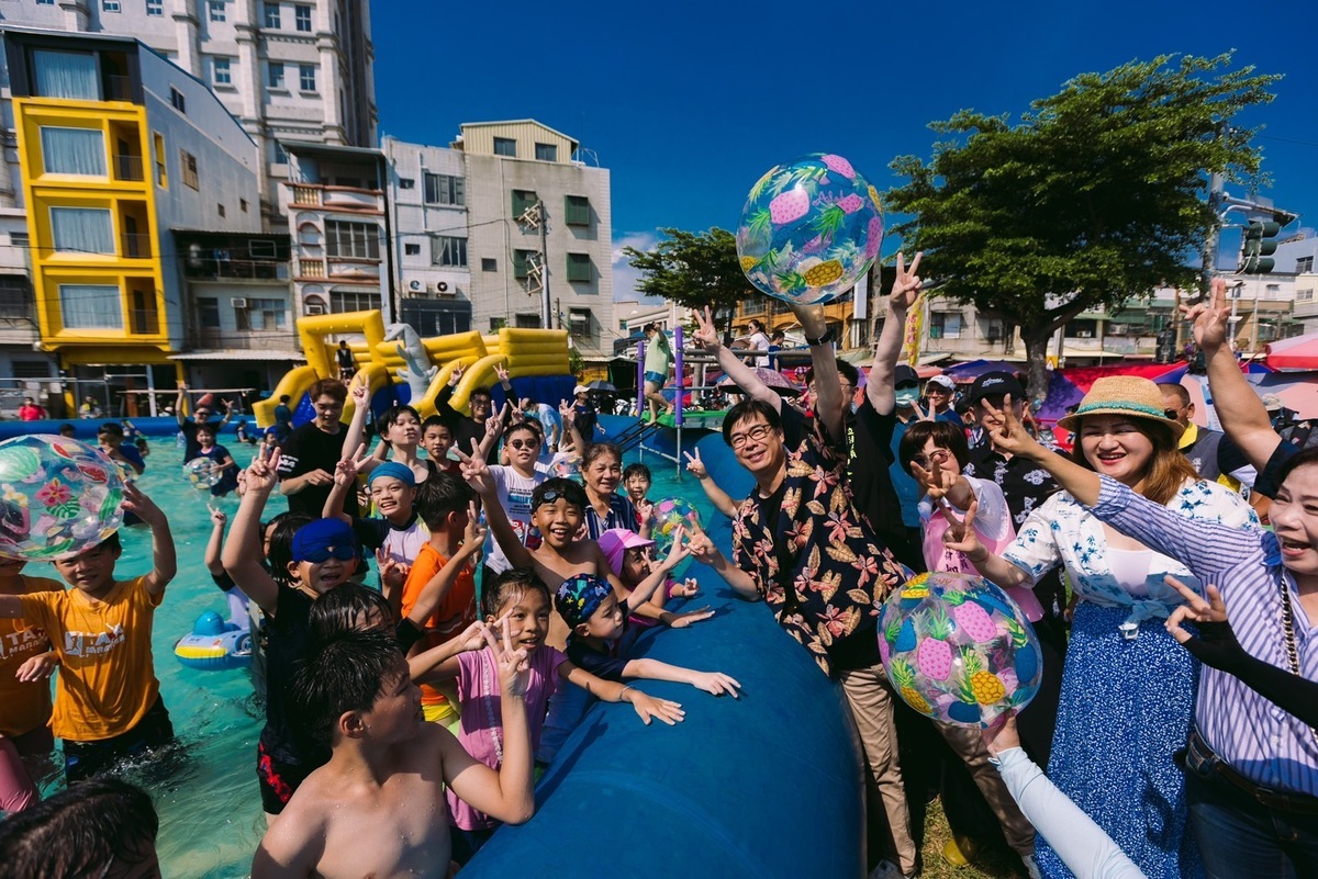 陳其邁(中)在氣墊水樂園與小朋友玩海灘球。 圖：高雄市觀光局提供
