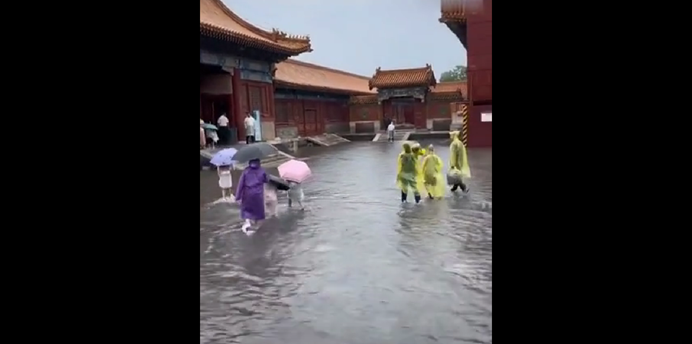 號稱 600 年未淹水的紫禁城近日因暴雨而淹水成災，遊客在積水內走動。 圖：翻攝自北京青年報微博