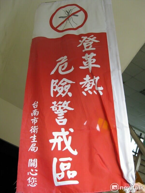 鑒於登革熱疫情嚴峻，南市政府登革熱防治中心特別製作紅色警戒旗，旗幟上標示「登革熱危險警戒區」字樣，當該區域出現本土登革熱確診病例時，即會請區公所將警戒旗插在鄰近顯眼處，提醒附近居民應嚴加防範。 圖：台南市政府提供