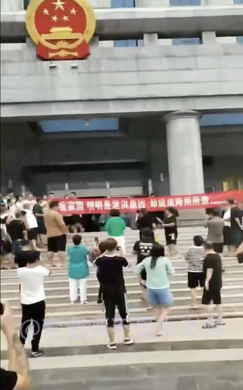 昨（ 4 ）日，河北省霸州市民高舉「還我家園，明明是洩洪原因，卻說降雨所致！」前往政府大樓抗議。 圖：翻攝自推特@whyyoutouzhele