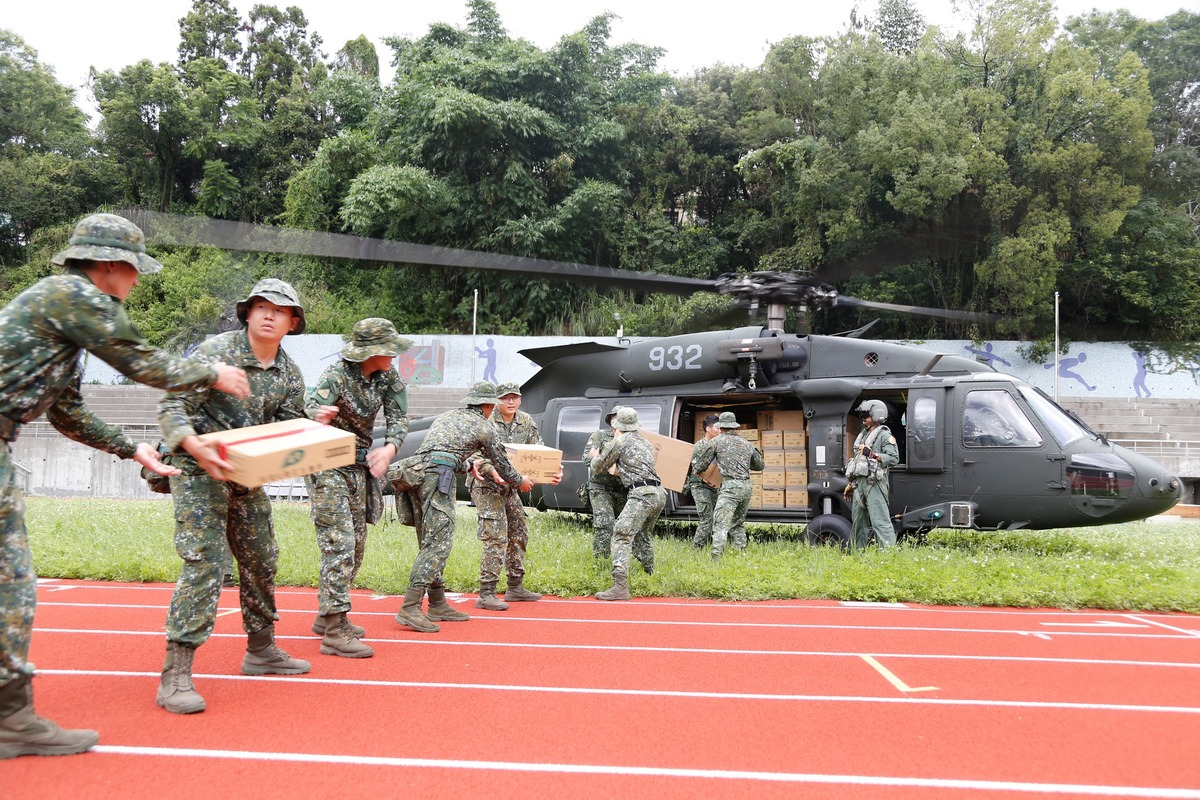 空軍救護隊的直升機滿載物資降落仁愛農工操場，由國軍官兵於地面接收，再轉運至各村落。 圖：翻攝國防部發言人臉書