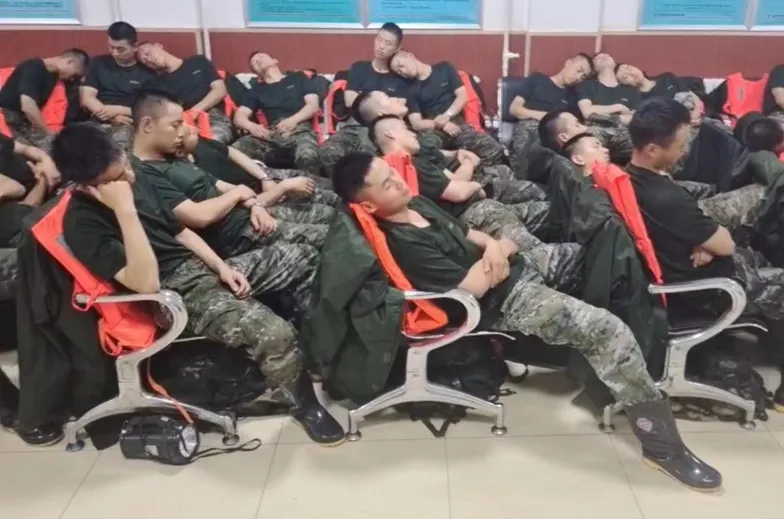 圖中清楚可見，這群武警們的雨鞋看起來極為乾淨，甚至能反射現場的燈光。 圖：翻攝自北京日報