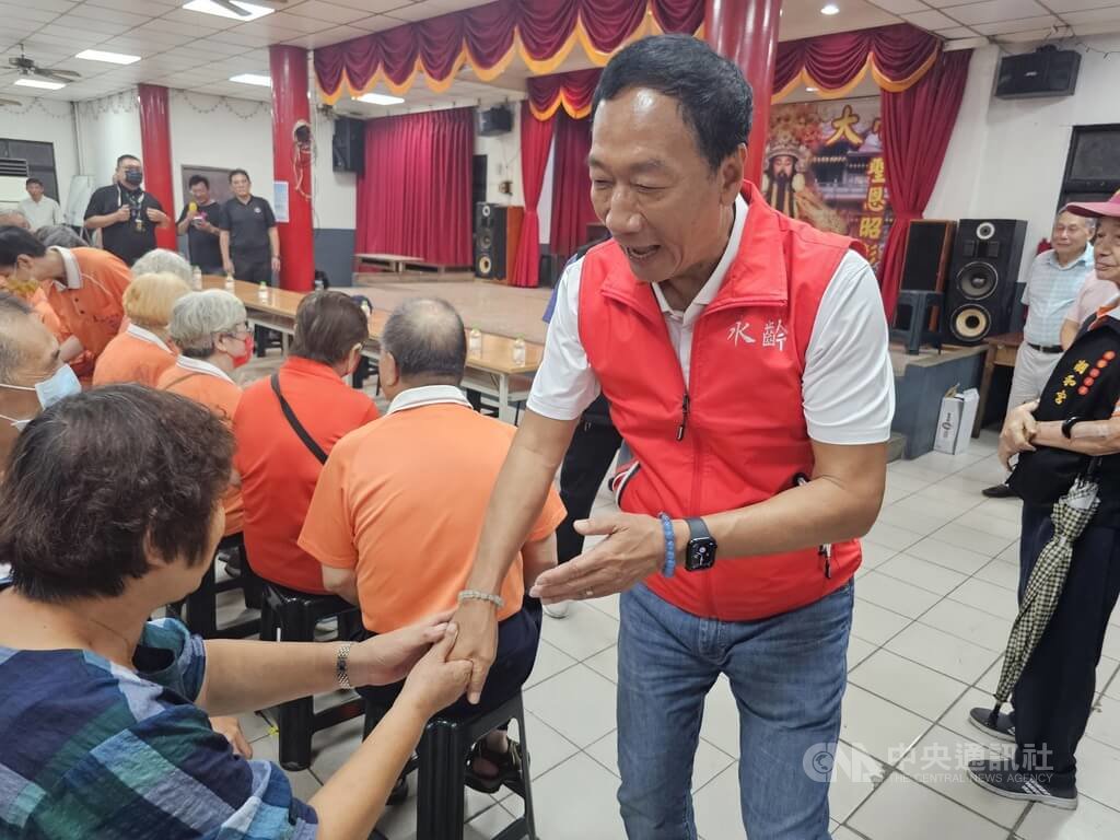 鴻海集團創辦人郭台銘（紅背心者）20日赴新北市板橋區潮和宮開講，表示若有機會出來服務大家，希望為台灣打造黃金30年，讓年輕人好好讀書，不用當兵，現場民眾力挺他「選總統」。 圖：中央社提供
