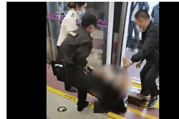 2021 年 8 月，一名女乘客在西安地鐵上遭保安拖拽出車廂，衣服被保安扯壞導致全身大面積裸露。 圖：翻攝自大紀元