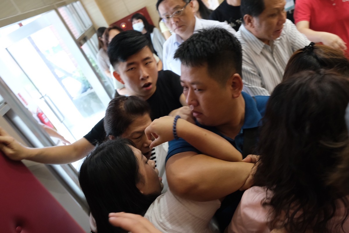 楊佩樺(左一)遭一名壯漢以肘壓制。 圖：台灣基進提供