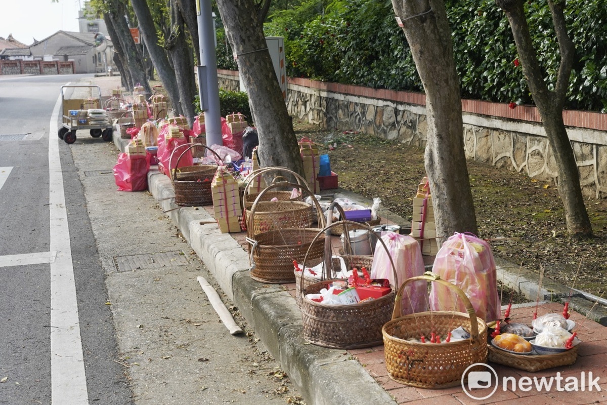 金門古寧頭村民在古寧頭國小外的馬路旁，擺放供品、紙錢祭拜在古寧頭戰役傷亡的國軍和中國解放軍陣亡的孤魂。很難想像74年前古寧頭戰役中，此地爆發激烈的巷戰，造成雙方數千名戰士的傷亡。 圖：張良一/攝