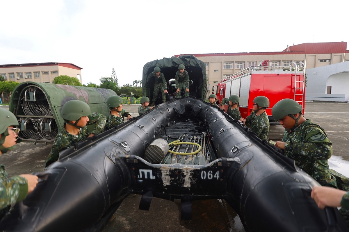 54工兵群官兵合力將舟艇搬運上車，待命執行救災任務。 圖：第四作戰區提供