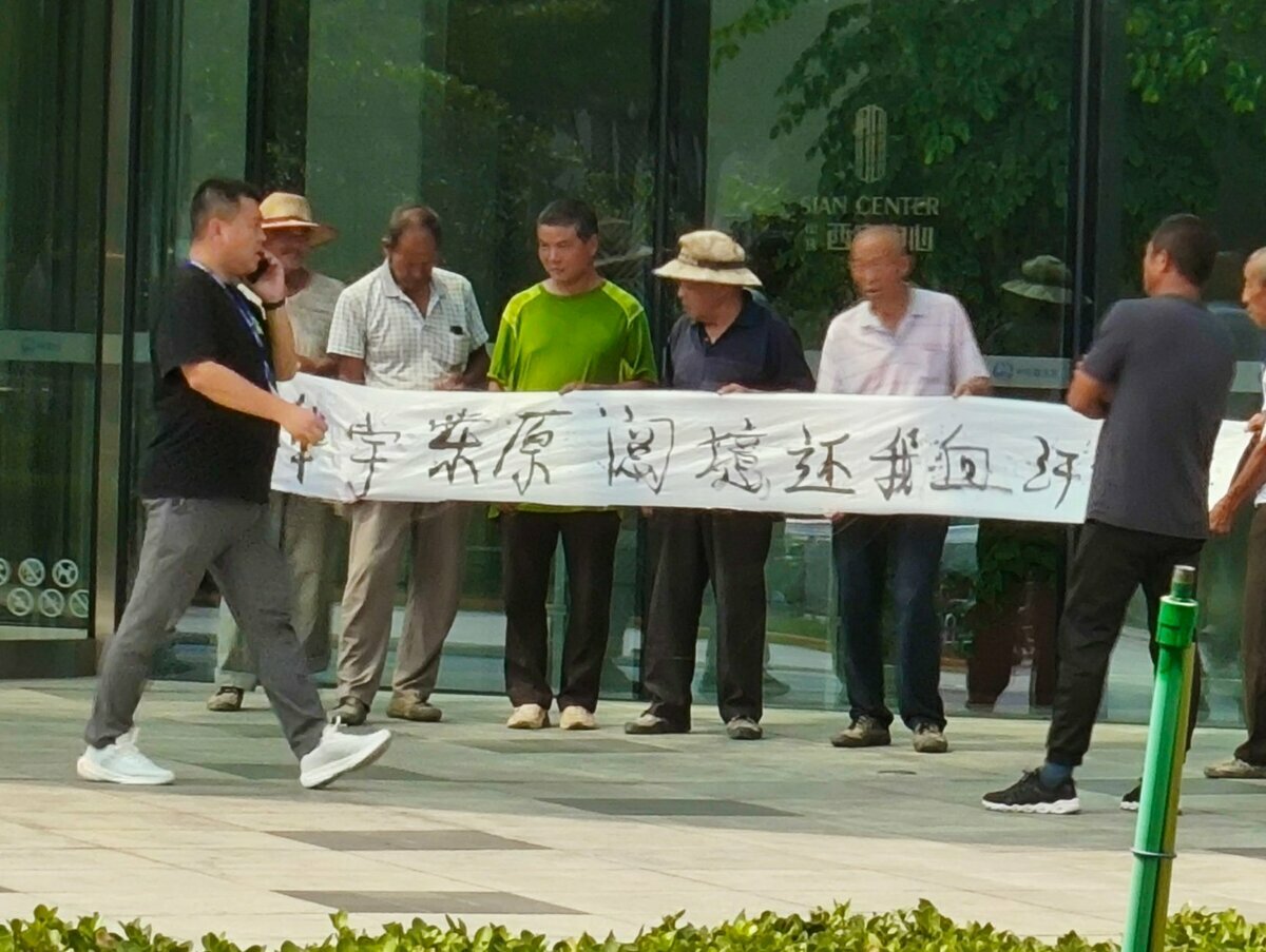 西安中心樓樓下的農民工拉著「華宇東原閱境還我血汗錢」的橫幅。  圖：翻攝自@whyyoutouzhele