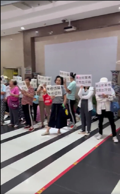 康橋暴雷受害者舉著「康橋詐騙、康橋還錢」與「康橋詐騙、政府做主」以及「揪出宋革偉、還我血汗錢」手板抗議 圖：翻攝自@whyyoutouzhele