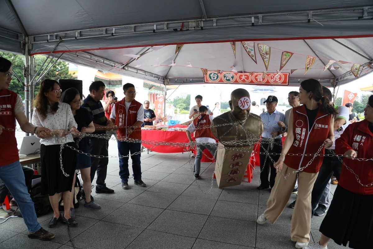 台灣基進於自由廣場牌樓前舉行2023台灣大普渡「祭台灣英靈 紱中國邪氣」活動，用鐵鍊拉倒象徵威權的蔣介石銅像。 圖：台灣基進提供