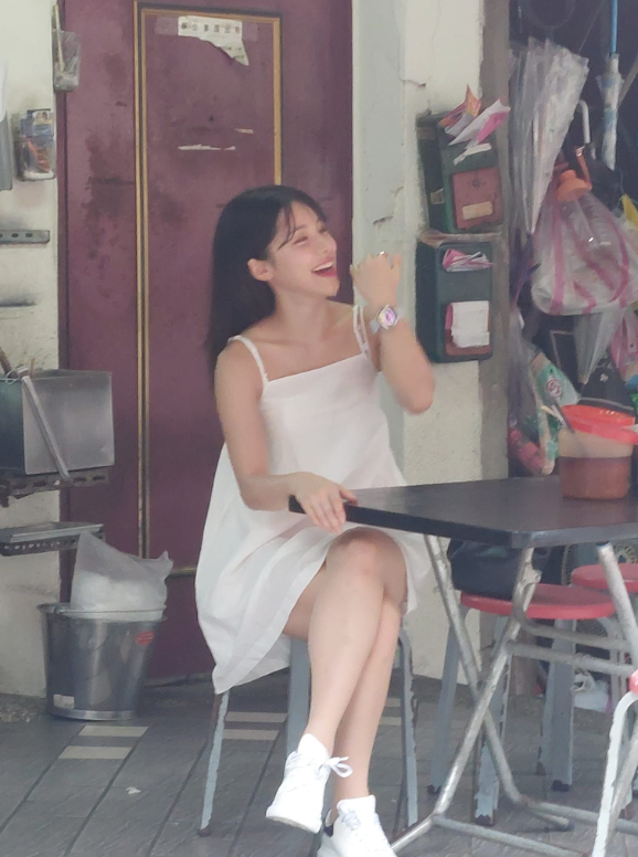李多慧身穿一襲白色的平口吊帶小洋裝，時不時整理頭髮並一邊燦笑，模樣相當甜美清新。 圖：翻攝自爆廢公社二館FB