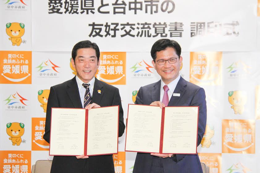 台中市長林佳龍（右）與日本愛媛縣知事中村時廣簽署「友好交流備忘錄」，兩地正式締結為友好城市。 圖：台中市政府提供