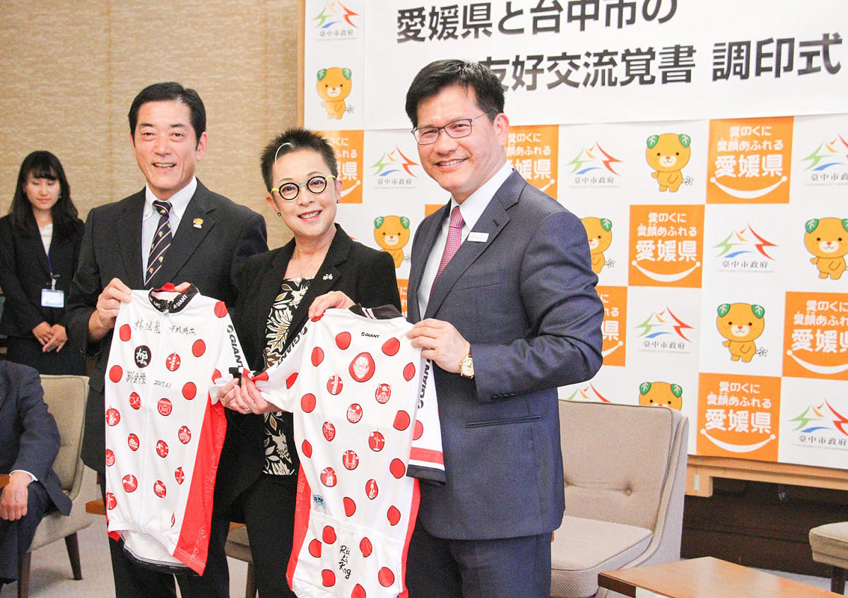 台中市長林佳龍（右）與日本愛媛縣知事中村時廣（左）在捷安特創辦人劉金標退休車衣簽名，互留紀念。 圖：台中市政府提供