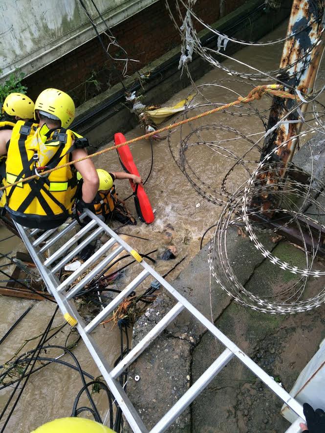 2017.06.02雷雨襲新北市八里一名騎機車的婦人掉入涵洞，遭大水沖進大排水溝，消防人員進行搶救。 圖:新北市消防局/提供