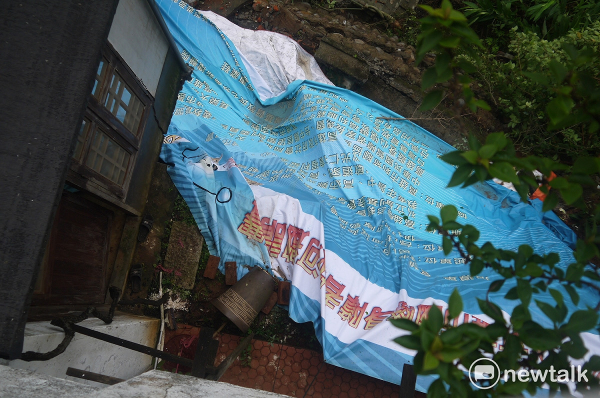 為防止建築地基遭大雨沖刷，居民以帆布覆蓋土地。 圖：鍾孟軒/攝