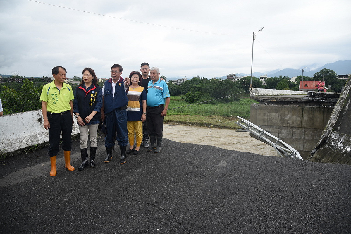埔里鎮蜈蚣里的青山橋因豪大雨影響，造成橋頭端道路路基掏空，電線桿也陷入空洞內。 圖：南投縣府提供