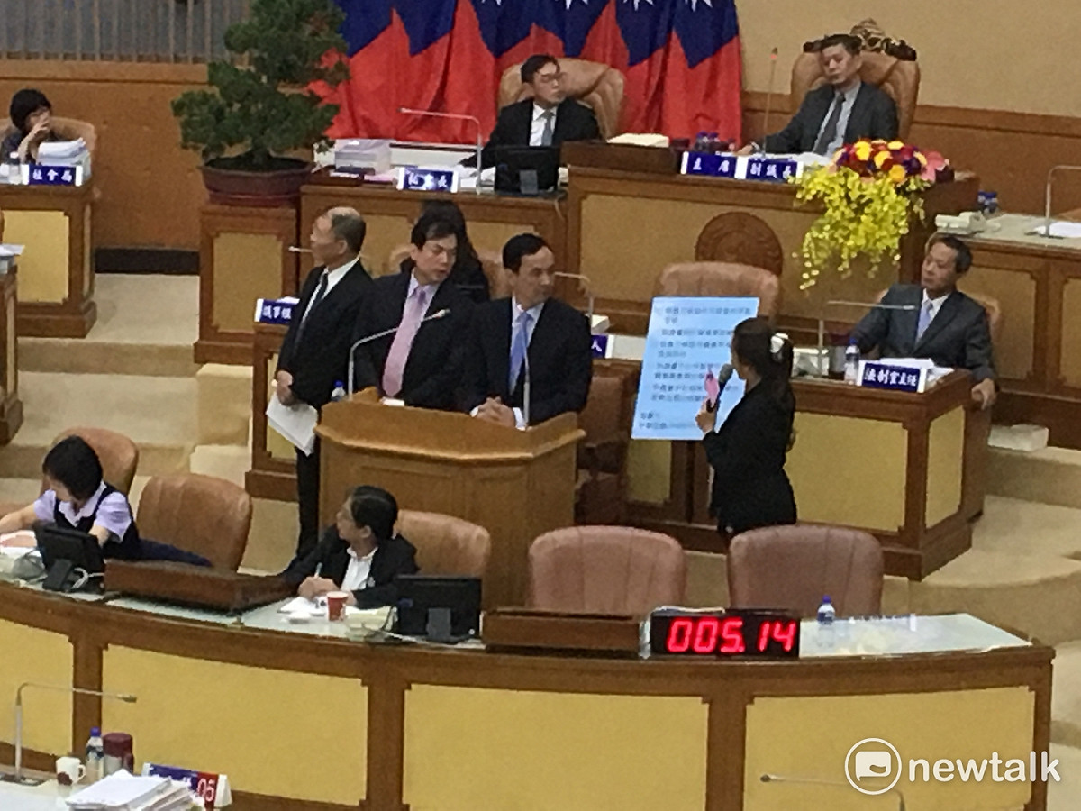新北市議員李婉鈺拿出承諾書要求新北市長朱立倫簽署。 圖：鍾孟軒/攝