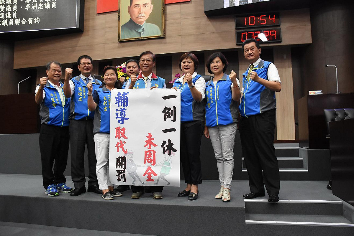 南投縣長林明溱(中)，6日在議會上帶頭高喊「一例一休未周全」、「輔導取代開罰」的口號。 圖：南投縣政府/提供