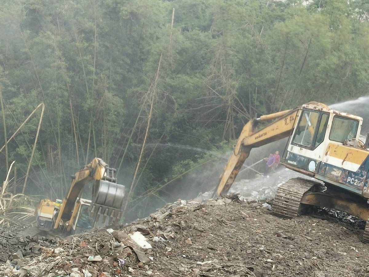 高雄市旗山區旗文路被棄置廢棄物數度悶燒冒煙，高雄市環保局出動灑水車6部，怪手1部，持續以怪手開挖及灑水，目前已暫時滅。 圖:高雄市政府提供