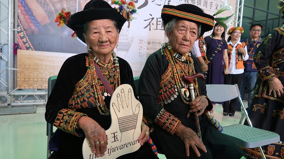 屏東縣政府8日舉辦排灣族手文展，88歲的手文耆老李碧玉（左）與87歲的賴金蘭（右）也一同出席手文展記者會 屏東縣政府提供