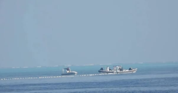 中國船隻在南海黃岩島上布置浮標攔索，阻擋菲律賓漁船進入。 圖 : 翻攝自華語智庫