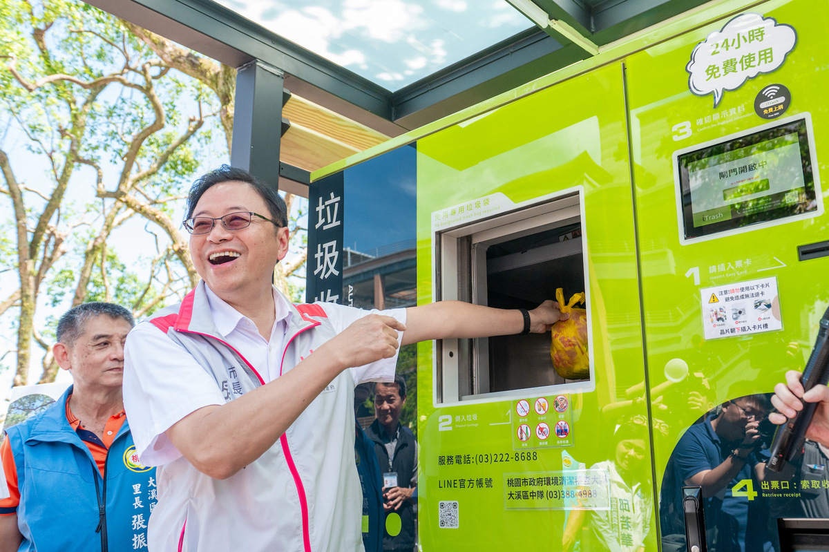 張善政持桃園市民卡體驗丟垃圾及保特瓶回收的流程。 圖：桃園市政府/提供
