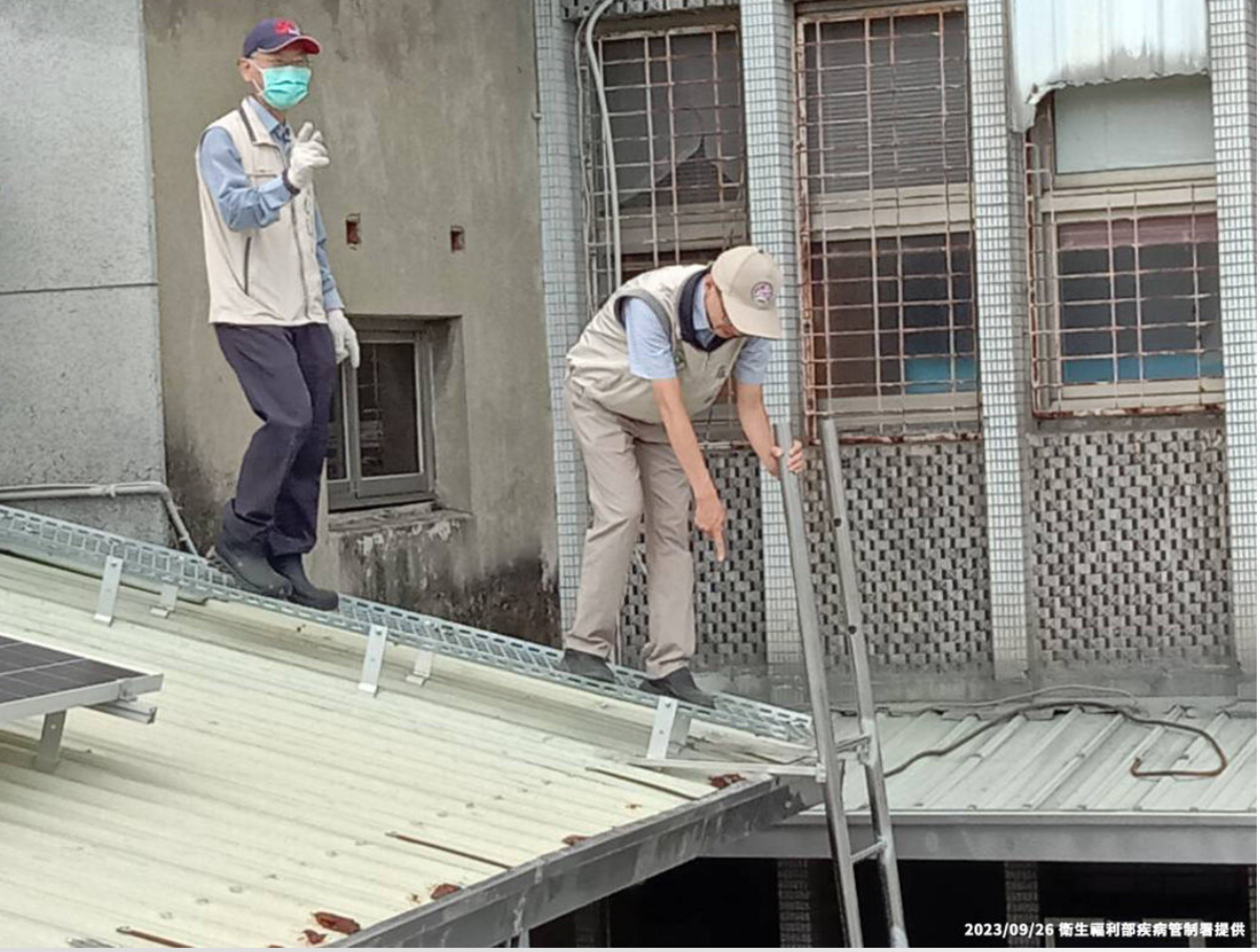 疾管署副署長羅一鈞親自爬上屋頂查看環境衛生，但卻沒有穿戴安全裝備，引發立委關切。 圖：疾管署／提供