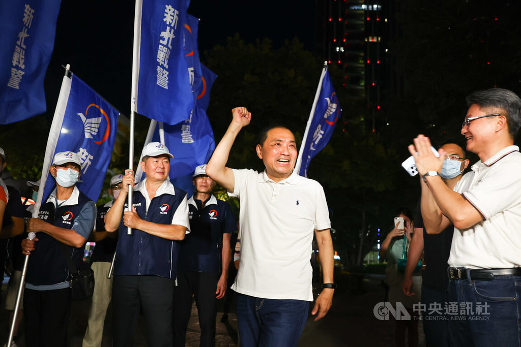 國民黨總統參選人侯友宜（前右2）29日晚間現身新北市板橋區深丘福德宮中秋聯歡晚會，現場有支持者高舉「新北戰警」旗幟到場為他加油打氣。 圖：中央社提供