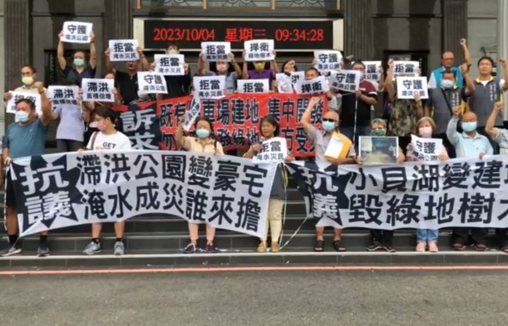 小貝湖守護聯盟颱風天至高雄市議會前舉白布條、標語喊口號。 圖：翻攝直播播面
