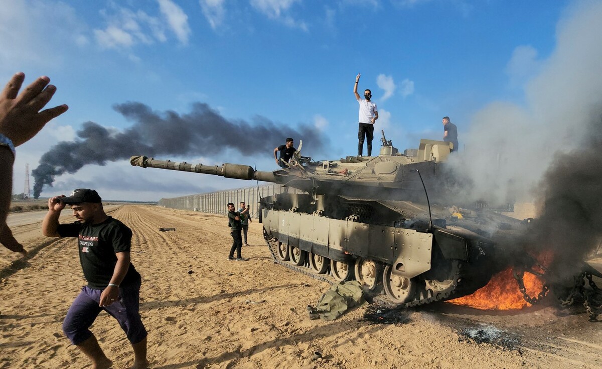 巴勒斯坦人在一輛被摧毀的以軍戰車上慶祝。 圖：美聯社／達志影像
