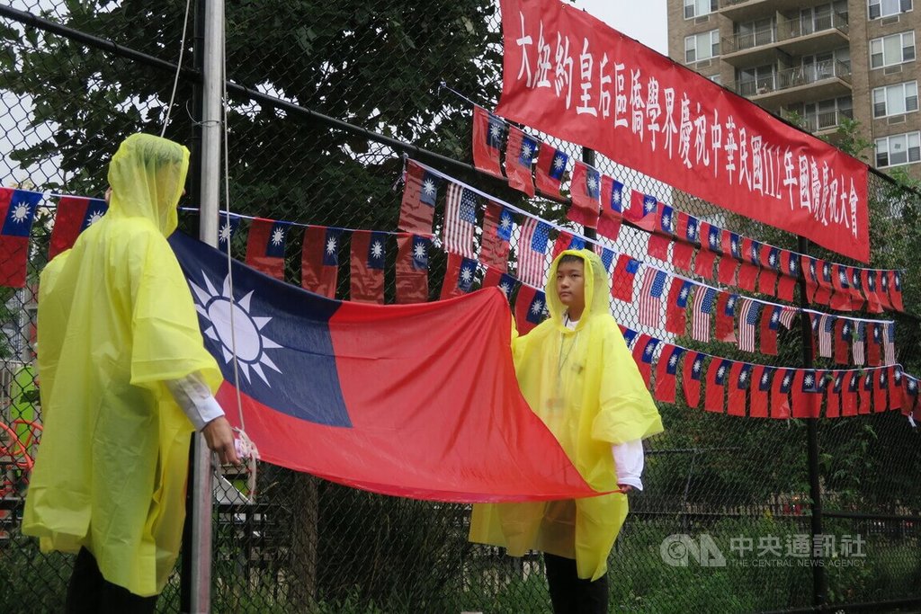 紐約市皇后區僑界7日在雨中舉行雙十國慶升旗典禮，僑務委員會海外青年文化大使協會（FASCA）學員擔任的旗手身穿雨衣。 圖中央社