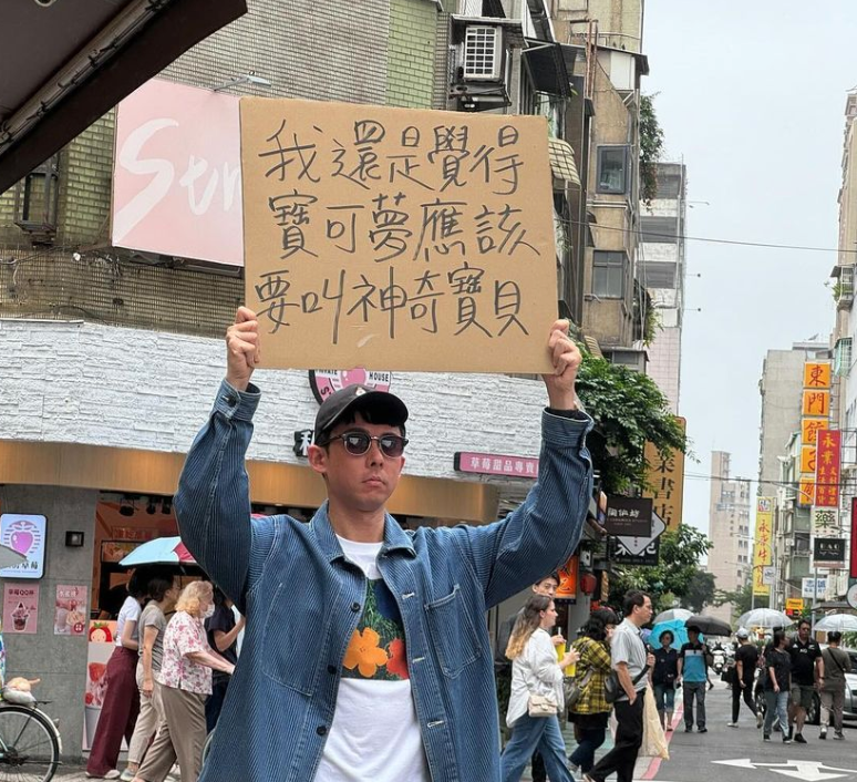阿滴舉牌「我還是覺得寶可夢應該要叫神奇寶貝」。 圖：翻攝自阿滴英文IG