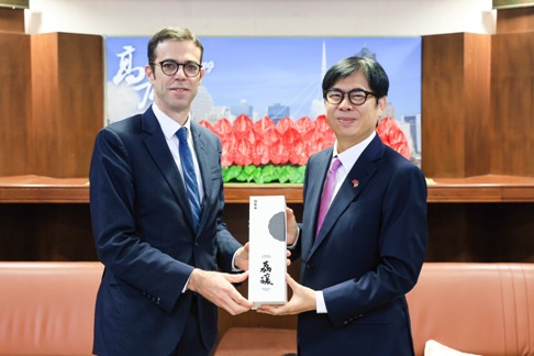陳其邁(右)致贈在地荔釀酒予巴黎思。 圖：高雄市行國處提供