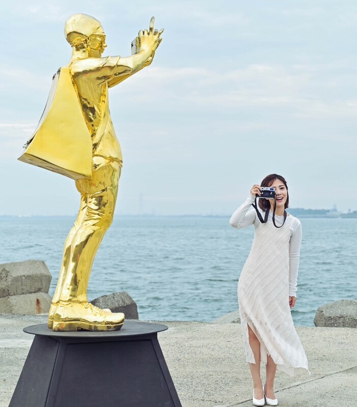 高市府發言人周璟瑜與「旅途之海-觀光」藝術作品合照。 圖：高雄市海洋局/提供
