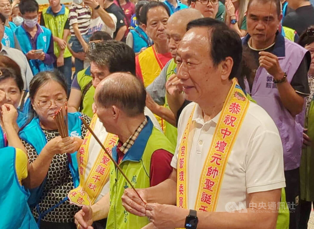 台南市麻豆太子宮平安宴21日晚間席開330桌，鴻海集團創辦人郭台銘（前右）到場參香祭拜並發送錢母，也和民眾合影。他指出，這次參選沒有任何目的，也不是要把錢放在口袋裡。 圖：中央社提供