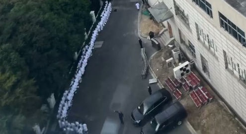 李克強逝世後，上海曙光醫院的醫護人員穿著白袍護送靈車離開。 圖:翻攝自Ｘ平台