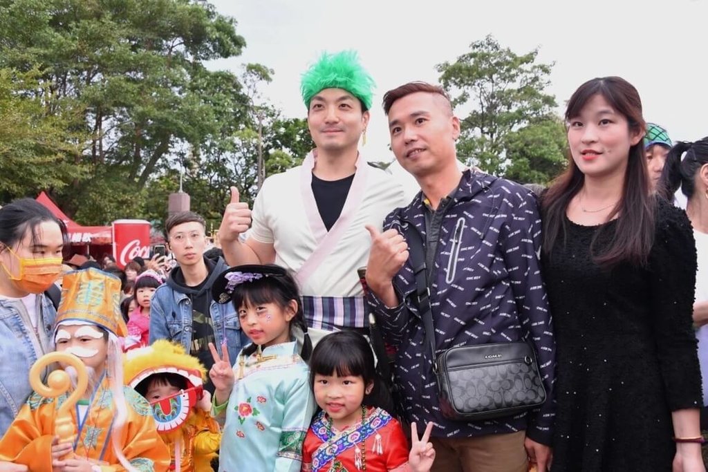 第15屆「天母搞什麼鬼」萬聖節嘉年華活動28日登場，台北市長蔣萬安（綠髮者）化身漫畫角色「索隆」現身，吸引許多民眾爭相合照。 圖：台北市政府提供