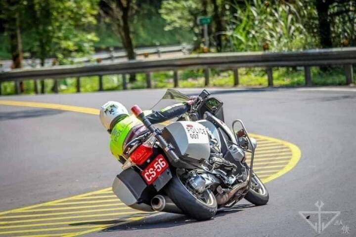 機車過彎角度小於 60 就會被開處罰鍰的政策，引發廣大網友不滿。有網友貼出照片嘲諷說，交警騎車過彎也是壓車。 圖：翻攝自臉書