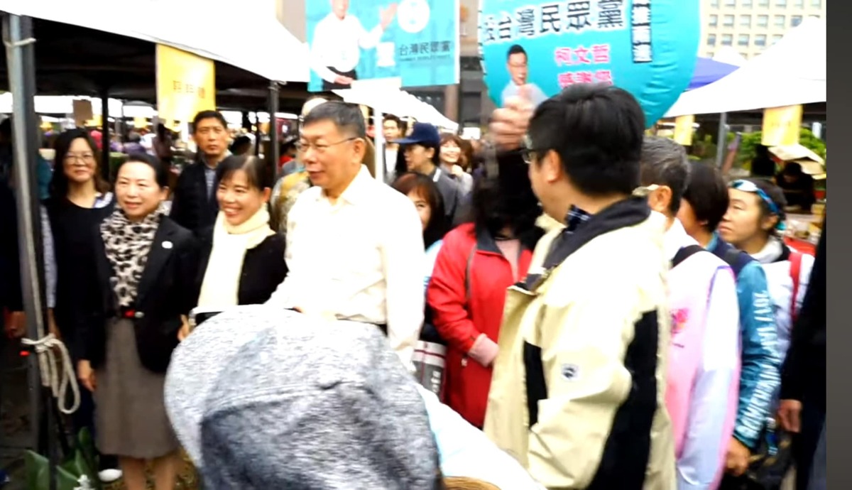 2019年北市「大江南北新住民園遊會」，會場上民眾黨宣傳政黨手舉牌、氣球明顯可見。柯文哲、徐春鶯與攤商合影。 圖：翻攝吳欣岱＠台灣基進臉書