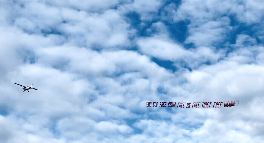 中國民運人士早上在東灣小型機場，以飛機拉開「終結共產黨」的巨型橫幅。 圖：趙昕提供