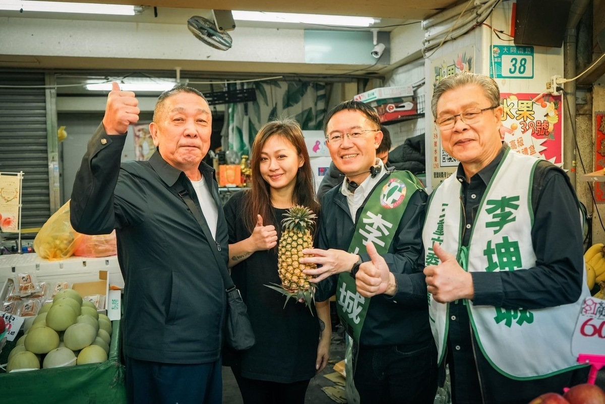 金曲歌王楊烈陪同民進黨新北市三重立委參選人李坤城市場造勢，攤商贈送鳳梨象徵「旺來」。 圖：李坤城競總提供