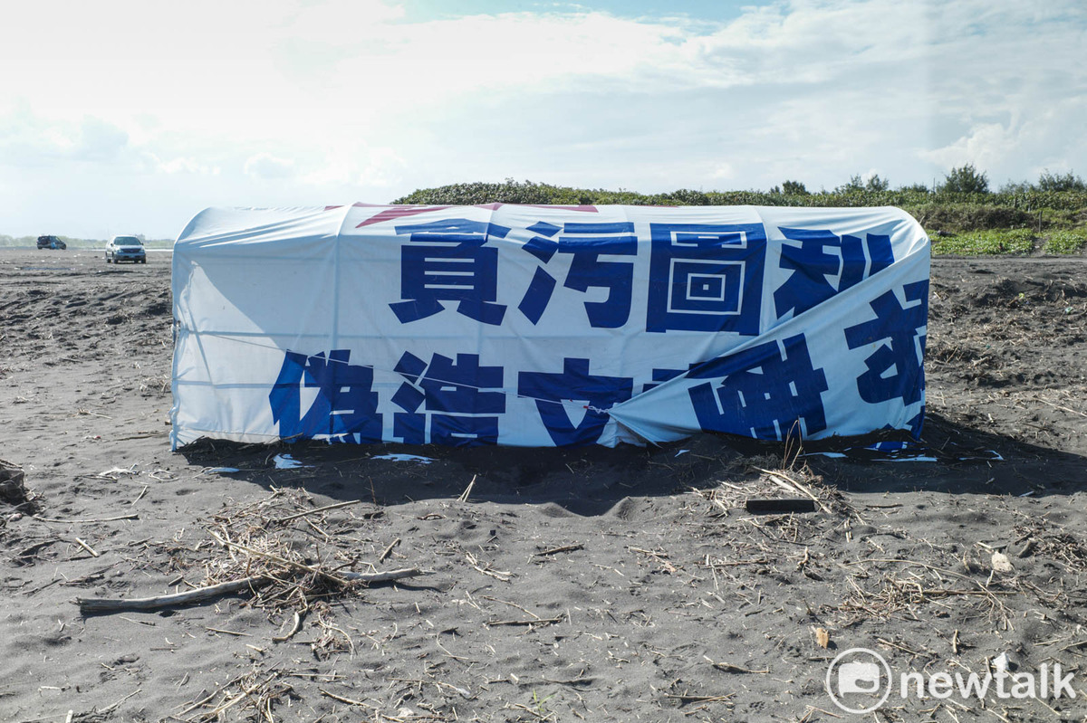 海灘上，競選帆布上攻擊對手的話僅露出支字片語，顯得相當突兀。 圖：張良一/攝