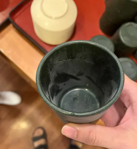 一名消費者在網路上PO文指出，於高雄一間迴轉壽司店用餐時，發現杯子裡外都沾有白色粉末。 圖：翻攝自Dcard