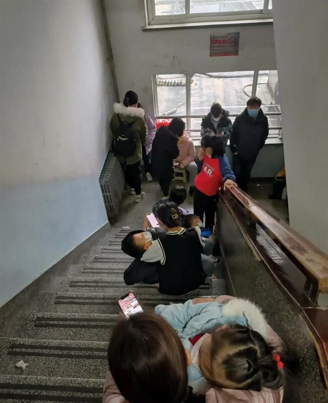 醫院樓梯間擠滿了排隊帶孩子看病的家長。 圖：翻攝自極目新聞