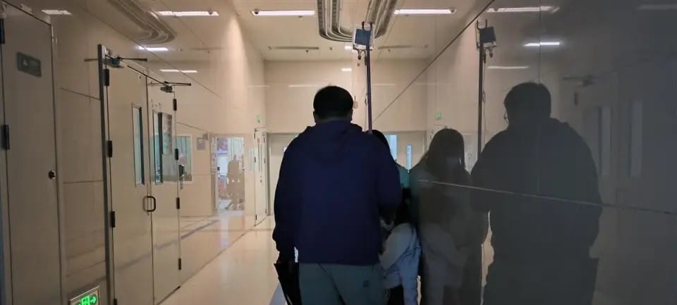 家長在醫院拿撐衣桿給孩子輸液。 圖：翻攝自極目新聞