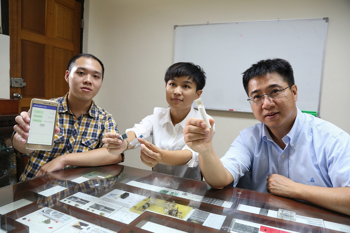 林哲信教授（右）花了五年時間成功研發「新型溶液感測器」，只要1秒鐘就能檢測出尿液、唾液、汗水等液體中的酸鹼度、溫度及離子濃度，數值上傳至雲端，遠端手機使用者即可快速掌握家人或患者的生理狀況。 圖：中山大學提供