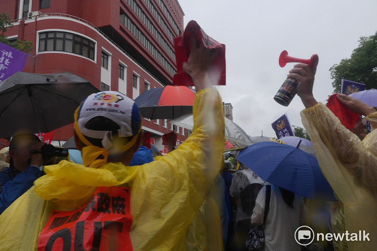 反年改抗議民眾先吹長達一分半的哨聲，再舉起「驅逐蔡政府，OUT」紙條，摟成一團後朝立法院方向丟擲過去。 圖：趙婉淳/攝