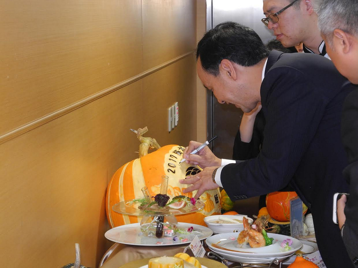 新北市「大南瓜比賽」即將登場，市長朱立倫上午大啖南瓜米粉、參觀各種品種南瓜、在大南瓜簽名，也與小朋友合影。 圖 : 王峻昌／攝