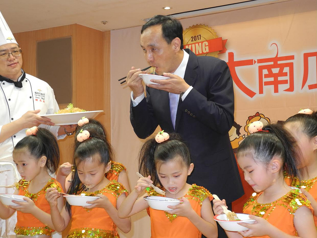 新北市「大南瓜比賽」即將登場，市長朱立倫上午大啖南瓜米粉、參觀各種品種南瓜、在大南瓜簽名，也與小朋友合影。 圖：王峻昌／攝