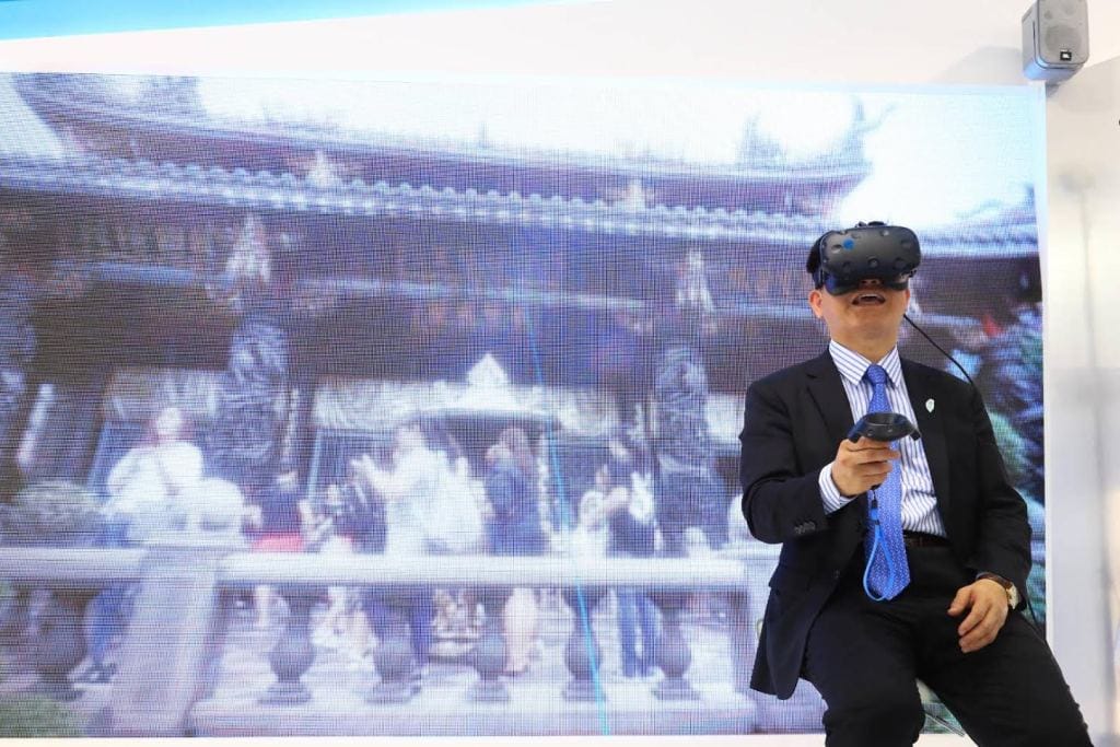 巴黎航空展台灣館國際記者會20日登場，台中市長林佳龍戴上VR眼鏡，親身體驗精密機械的虛擬實境技術。 圖:台中市政府提供